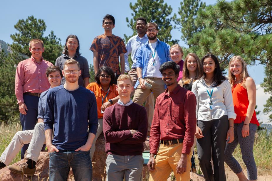 Group photo of 2018 interns outdoors near the NCAR Mesa Lab, with trees and blue sky in the background.