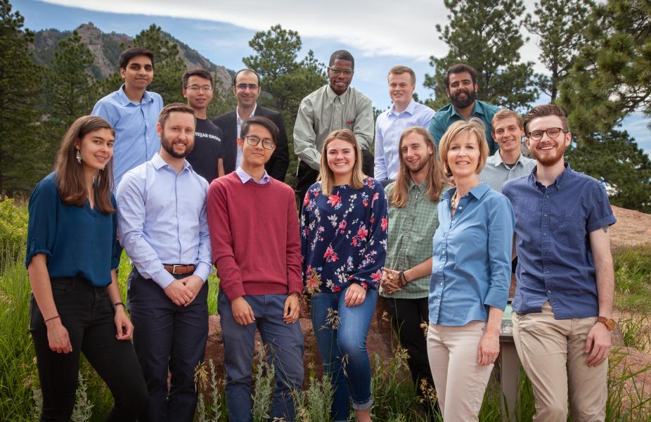 Group photo of 2019 interns, outdoors with trees and Boulder Flatirons in the background.